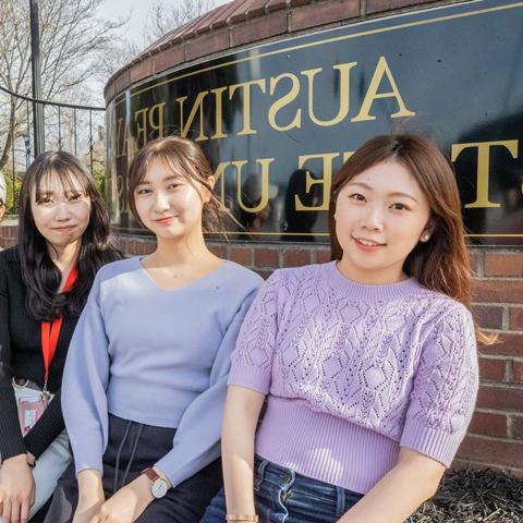 Japanese exchange students in front of the Austin Peay sign on College Street.